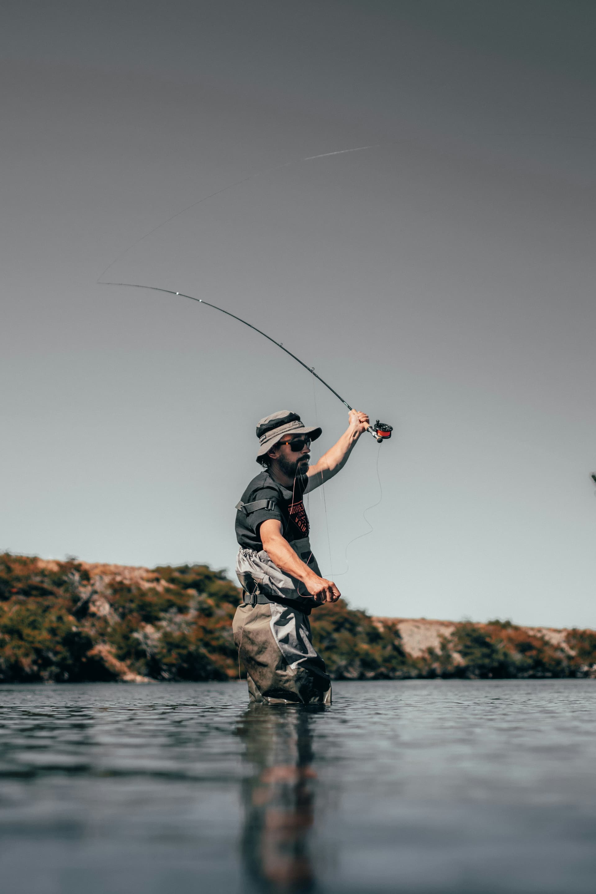 Angler casting a fly rod on open water