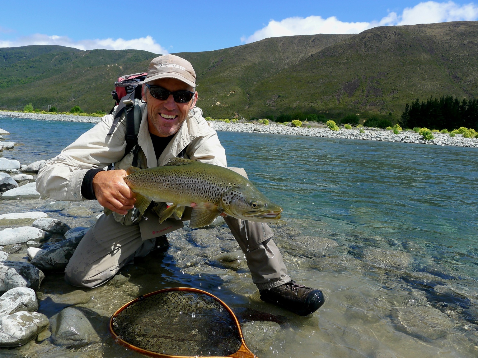 Smiling angler with large brown trout
