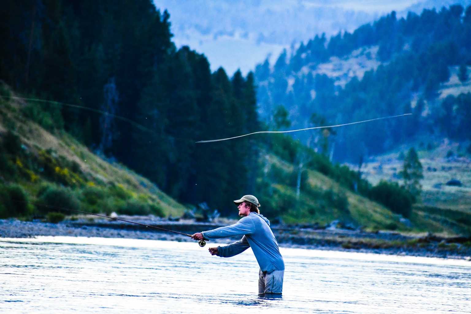 Man casting in early morning light