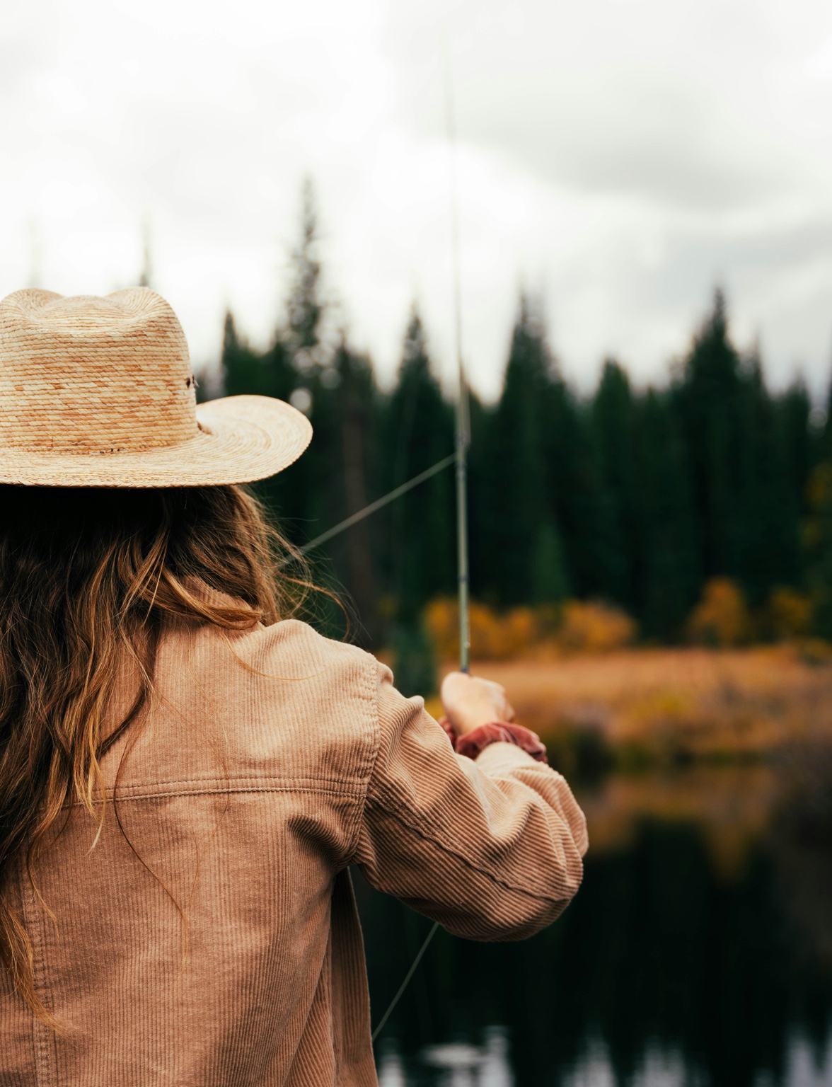 Woman fly fishing in hat - brand story